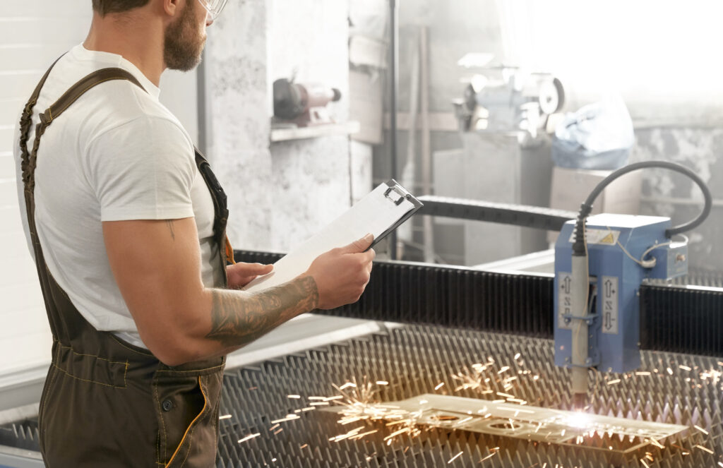 Engineer controlling plasma laser cutting metal