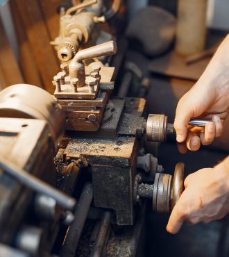 Man working with a wood. Carpenter in a white shirt
